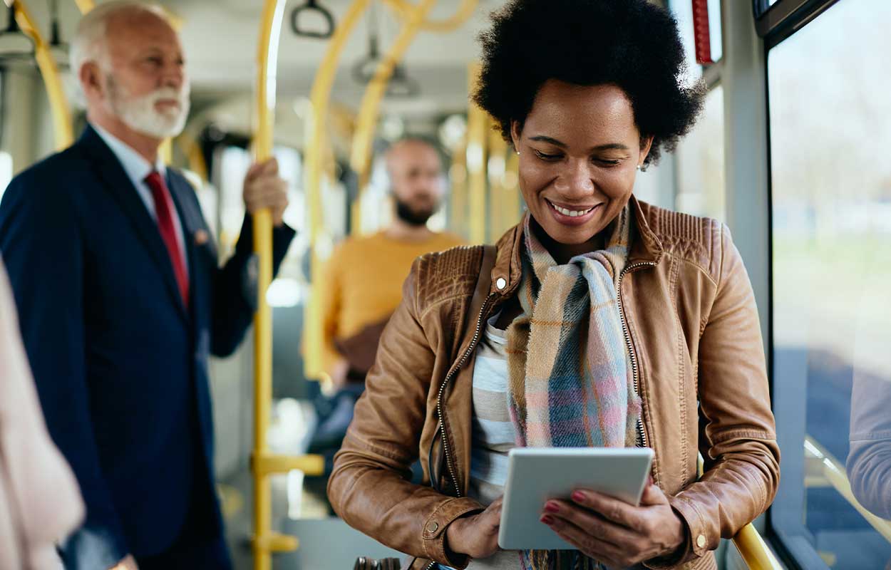 Mujer leyendo en una tablet mientras realiza un viaje en autobús